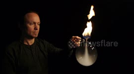 Bubble artist performs handheld fire tornado bubble trick