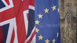 Union Jack and EU flags fly in front of the Houses of Parliament