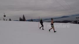 Man jogging bare-chested down ski slope