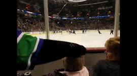 Cheeky mascot messing with senior's hair during hockey game
