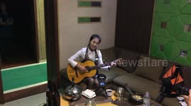 North korean girl sings and plays the guitar in Pyongyang