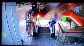 Naughty student climbs onto escalator handrail and falls one storey