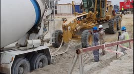 Construction crew films cat hauling out truck stuck in sand