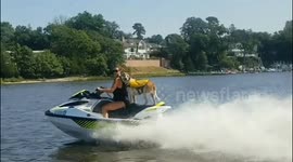 Dog riding on back of jetski with sunglasses