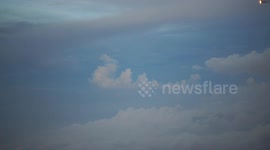 Santa on his sleigh in the clouds wearing a top hat.