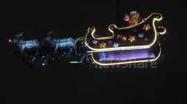 Santa Claus rides through the sky over Paris