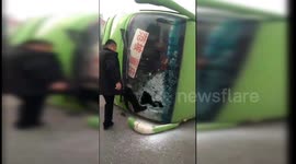 Car hits bus, flipping it over and trapping passengers inside