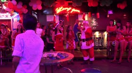 Santa Clause outside Toy Bar in Bangkok, on Christmas night delivering gifts to everyone in the street.