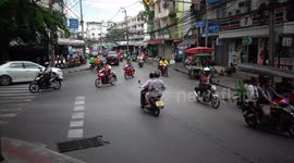 Motorcycles negotiate chaotic junction in Thailand