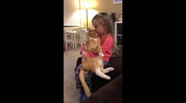 4 year old holds cat while he snuggles into her.