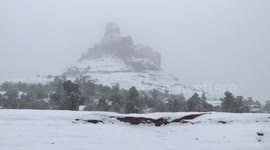 Snow falling in the desert at Bell Rock in Sedona, Arizona.