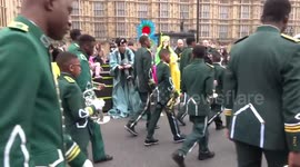 Stilt-walkers undoing their stilts outside the Houses of Parliament at the finish of London New Year Day Parade 2019