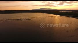 Aerial, beautiful giant swamp situated in Tuscany, Italy on sunset