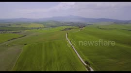 Aerial, beautiful green hills and fields and cypresses landscape in Tuscany, Italy