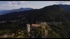 Aerial, medieval tower Rocca Di Sassi and a cemetery on top of the Apuan Alps in Tuscany, Italy