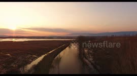 Aerial, beautiful fall landscape on a big pond  on sunset with low water and sun reflections
