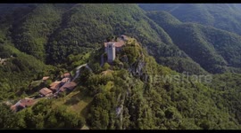 Aerial, medieval tower Rocca Di Sassi on top of the Apuan Alps in Tuscany, Italy