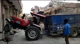 Whoops! Tractor driver gets stuck in between houses