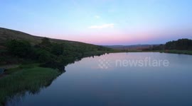 BEAUTIFUL DRONE FOOTAGE OF AN AFRICAN DAM AT SUNSET THROUGH A FLOCK OF BIRDS 4K