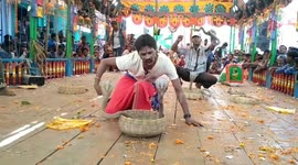 Man performing stunt clinching venomous snakes in between teeth while drinking water