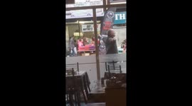 Man dancing and singing using a tennis racket