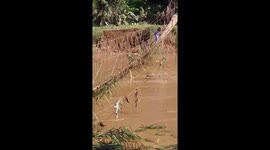Teachers make perilous commute to classroom by walking across half-sunken rope bridge