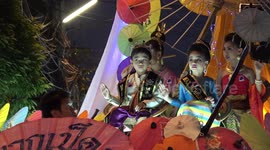 Thai locals wear traditional dress for evening parade at umbrella festival