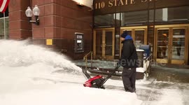 Northeast Snowstorm: Man with snow-blower clears sidewalk in Albany