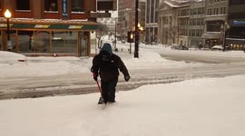 Northeast snowstorm: Man struggles to walk through snow bank in Albany