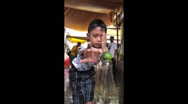 Dizzy kids try to flick lime from bottle top in amusing party game