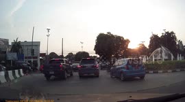 Collision between a car and a cement truck at a busy roundabout.