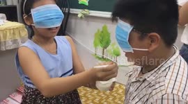 Blindfolded children race to feed each other yoghurt at birthday party