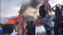 Masked protesters throw projectiles at Venezuela riot police