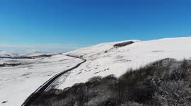 Flying a drone over snowy trees at Mam Tor in the Hope Valley in Derbyshire, 4K