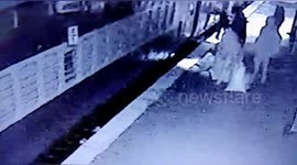 Indian poilce rescued women who fell in the gap in running train in India.
