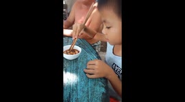 The five-year-old boy likes to eat live coconut worm
