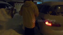 man shovelling deep snow early in the morning