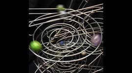 Hypnotic machine sends marbles shooting down a twisting set of metal coils