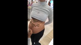 World record holding henna artist tattoos pregnant woman's baby bump