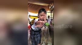 Dizzy kids try to flick lime from bottle top in amusing party game