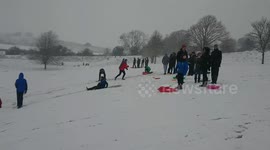Revellers in UK's Salisbury enjoy sledging in the snow