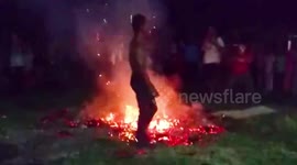 Dancers kick around red-hod coals during performance in flames
