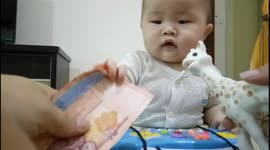 Smart baby loves money more than his toy
