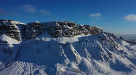 Drone view of magnificent snow-covered Binevenagh mountain in Northern Ireland