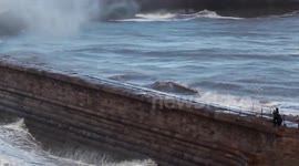 Dogwalkers risk lives on harbour wall during 'weather bomb' in UK
