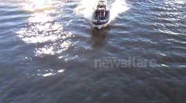 James Bond going under Vauxhall Bridge London in a speed boat filming the new Spectre film