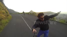 Electric skateboarding up mountain filmed with selfie stick