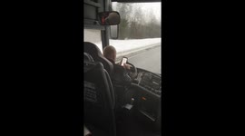 Bus driver types messages with both hands while driving on icy road