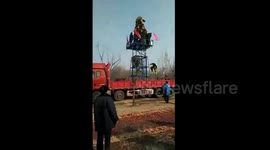 Chinese lion dancer falls off high platform on truck after failing somersault
