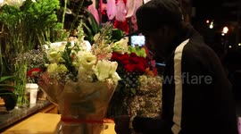 Flower shop worker ties ribbon around Valentine’s Day bouquet